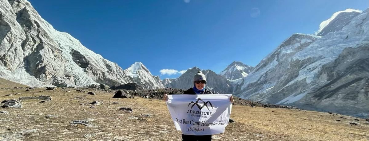 Happy customer holding Everest Heli Tour completion banner at the Himalayas happy-customer-after-everest-helicopter-tour